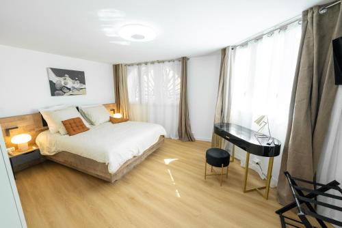 a bedroom with a bed and a desk in it at Appartement rénové avec parking quartier historique in Bordeaux