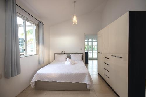a bedroom with a bed and a large window at Bahari Villa Beachfront in Port Louis