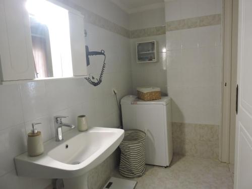 a white bathroom with a sink and a toilet at Sweet Suites in Amalias
