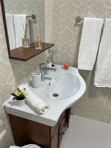 a bathroom with a sink and a mirror and towels at Dare apartments 2 in Giurgiu