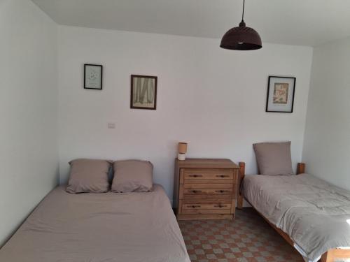 a bedroom with two beds and a wooden dresser at L'escale de Blacourt in Blacourt