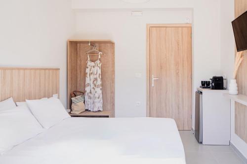 a bedroom with a white bed and a kitchen at Theoni Garden in Parga
