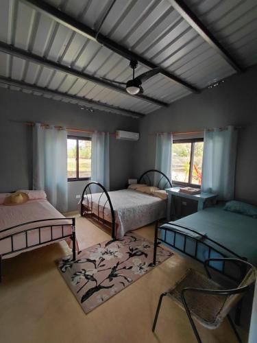 a room with two beds and two tables and windows at Sansalo Lounge Capira in Lídice