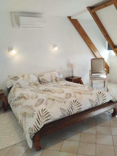 a bedroom with a bed and a chair at L'épi de blé in Saint-Astier