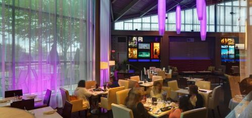 people sitting at tables in a restaurant with purple lighting at Executive Plaza Hotel & Conference Centre, Metro Vancouver in Coquitlam