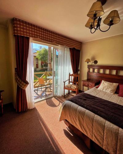 a bedroom with a bed and a door to a patio at El Copihue Olmué in Olmué