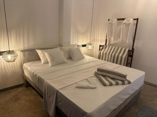 a large white bed with two pillows on it at Era 25 in Ahangama