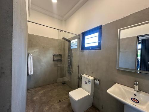 a bathroom with a toilet and a sink and a shower at Era 25 in Ahangama