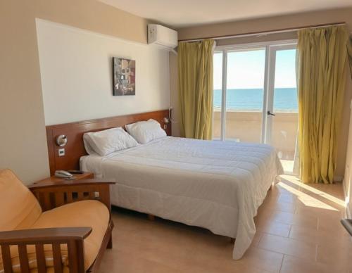 a bedroom with a bed and a balcony with the ocean at hotel Villa Gesell Spa in Villa Gesell
