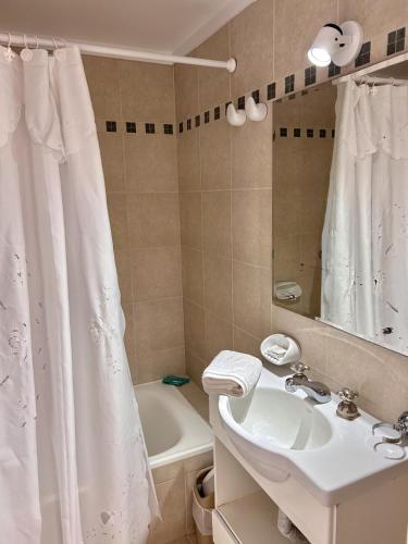 a bathroom with a sink and a shower curtain at hotel Villa Gesell Spa in Villa Gesell