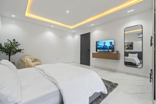 a bedroom with a bed and a tv on the wall at Mex 1 bedrooms Lekki phase1 in Lagos