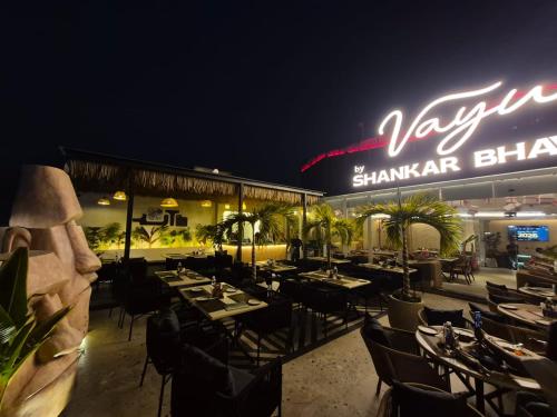a restaurant with tables and chairs in front of a building at Shankar Bhavan By Vinayak Hotels in Brahmapur