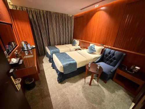 a hotel room with a bed and a chair at كلاديوم in Medina