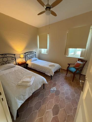 a bedroom with two beds and a ceiling fan at PALIO LIMANI HOUSE in Spetses
