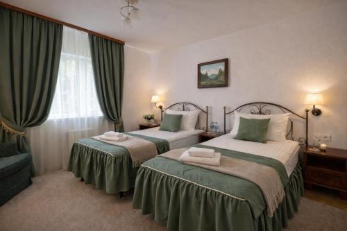 a hotel room with two beds and a window at Gusarskiy Hotel and Apartment in Kyiv