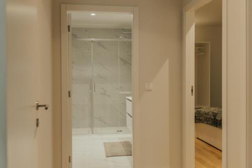 a bathroom with a walk in shower next to a bed at Termas do Gerês Studio in Geres