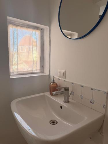 a white sink in a bathroom with a mirror at Leone XIV Firenze in Florence