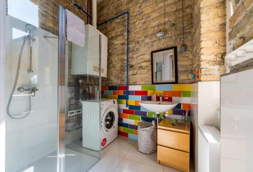 a bathroom with a washing machine and a sink at Mignon Szeged Apartman in Szeged