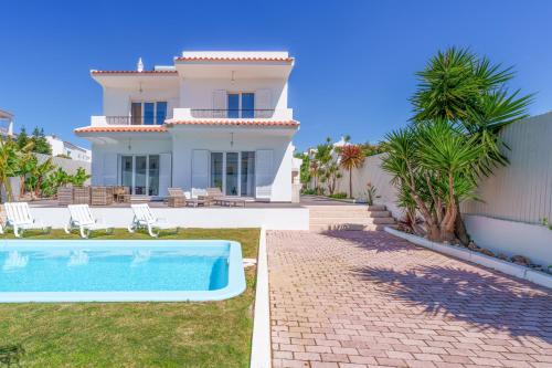a villa with a swimming pool in front of a house at Large Villa - Private Pool - 6 Bedrooms in Albufeira