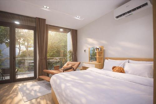 a bedroom with a large bed and a large window at Board & Beyond House in Danang