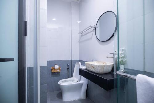 a bathroom with a sink and a toilet and a mirror at Board & Beyond House in Danang