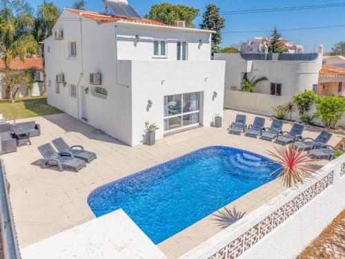 a villa with a swimming pool in front of a house at Oura - Large Villa - Private Pool - 5 Bedrooms in Albufeira