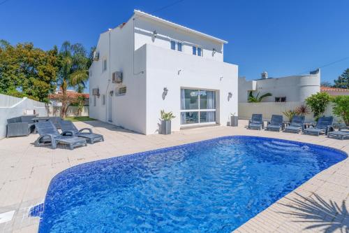 a villa with a swimming pool in front of a house at Oura - Large Villa - Private Pool - 5 Bedrooms in Albufeira