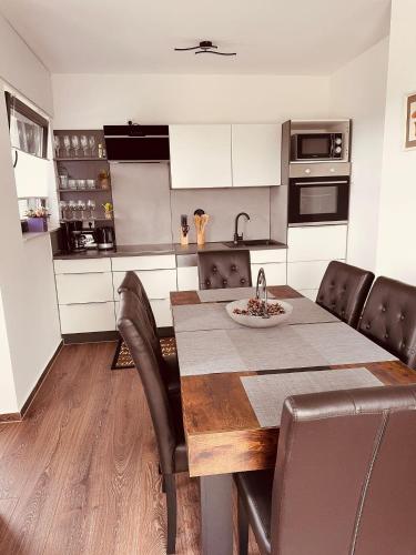 a kitchen with a wooden table and leather chairs at Haus-Elena-Wohnung-7C in Bestwig
