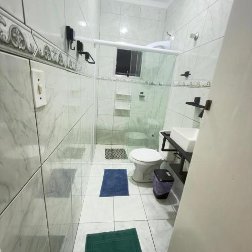 a bathroom with a shower and a toilet and a sink at Host Família Catarina in Guarulhos