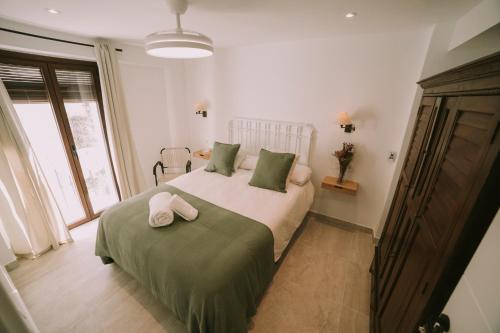 a bedroom with a bed with two towels on it at Casa Aula Minerva Lumen 3 Dormitorios in Almedinilla