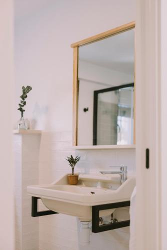 a white bathroom with a sink and a mirror at Casa Aula Minerva Lumen 3 Dormitorios in Almedinilla