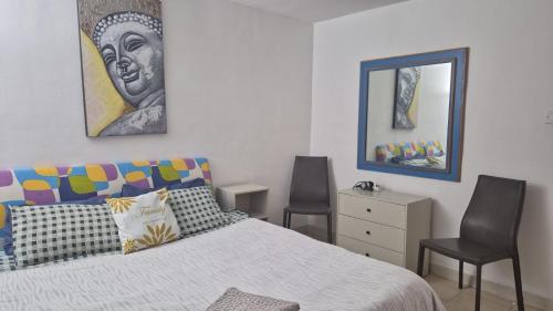 a bedroom with a bed with two chairs and a mirror at Olivier House Mellieha in Mellieħa