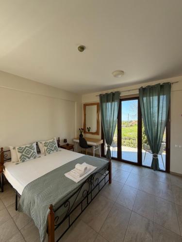 a bedroom with a large bed and a large window at Daniel's Hotel Apartments in Paphos