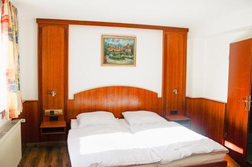 a bedroom with a bed with a wooden head board at Hotel Restaurant Blumenhof in Baesweiler