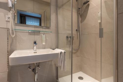 a bathroom with a sink and a shower at Hotel Residence in Würzburg
