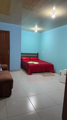 a bedroom with a red bed in a blue room at Hotel e Residencial Solar in Uruara
