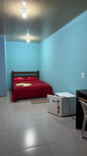 a bedroom with a red bed and a blue wall at Hotel e Residencial Solar in Uruara