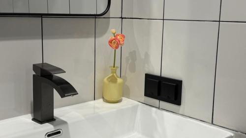 a sink with a vase with a flower in it at Smile Residence Bishkek in Bishkek