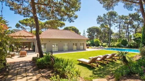 a house with a yard with a swimming pool at The Olive Villa Cascais Vive el lujo sereno entre pinares junto al Atlántico 5 minutos de la playa andando in Cascais