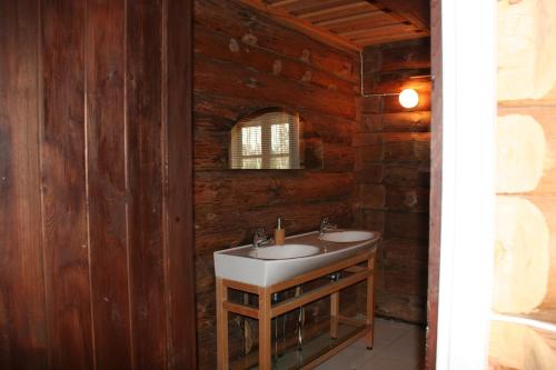 a bathroom with a sink in a wooden wall at Miškiniškės in Ignalina