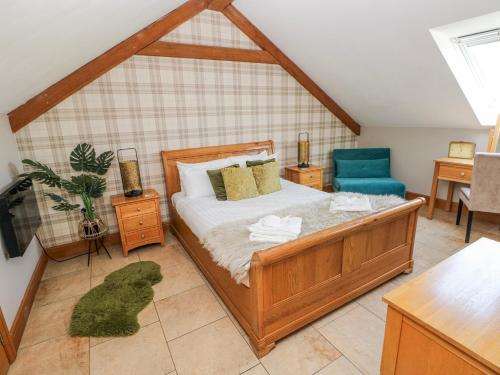 a bedroom with a bed and a blue chair at Willow Apartment - Gower in Swansea