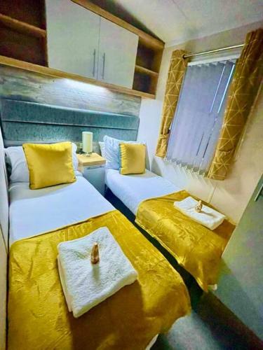 two beds in a small room with yellow sheets at Static in Peak District Ashbourne Heights Derbyshire Play Park Indoor Pool in Tissington