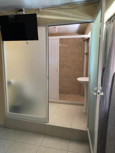 a bathroom with a glass door leading to a shower at Hotel Plaza Aleman in León