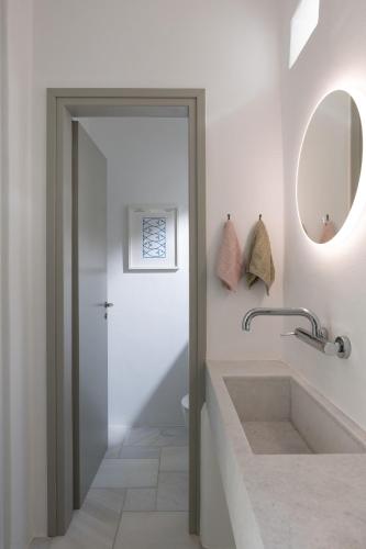 a bathroom with a sink and a mirror at Villa AVRA, a serene Cycladic villa with private pool overlooking the Aegean Sea in Batsi