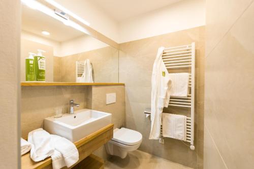a bathroom with a white sink and a toilet at Berghotel Tyrol in Senales