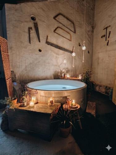 a bathroom with a tub and a table and candles at AMEIO - Country House in Rio Maior
