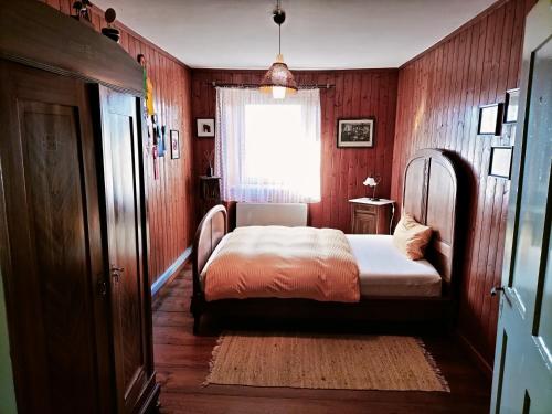 a bedroom with a bed in a room with wooden walls at B&B Herberg im Eichberg in Dettighofen