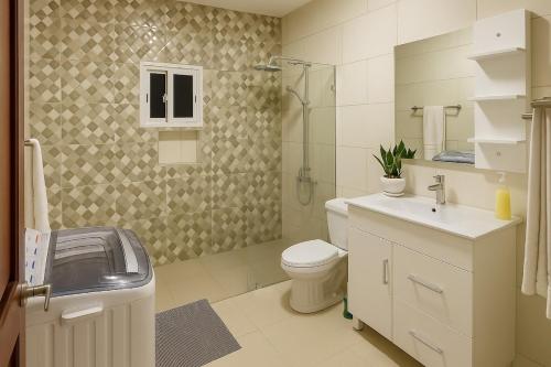 a bathroom with a toilet and a sink and a shower at Spacious Home with Private Pool in San Felipe de Puerto Plata