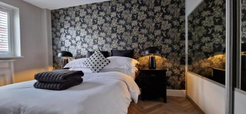 a bedroom with two beds with black and white wallpaper at Kings Sconce in South Muskham