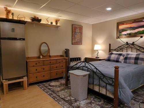 a bedroom with a bed and a dresser and a refrigerator at Private White Mountains Guest Suite - Welcome! in Littleton